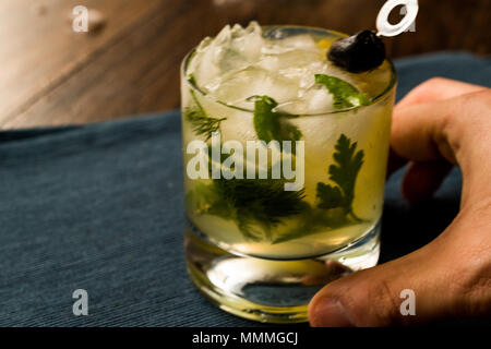 Dillionaire Cocktail mit Dill, Gin, Petersilie, Zitrone, Olivenöl und Crushed Ice. Beverage Konzept. Stockfoto