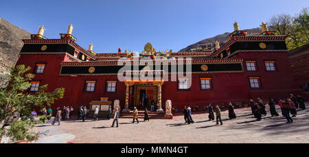 Tibetischen Pilger wandern Kora Kreise um den heiligen Bakong Schrift Druckmaschine Kloster in Dege, Sichuan, China Stockfoto