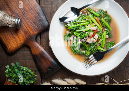 Thai Food: gebratenen Kohl mit getrockneten Fische gesalzen auf hölzernen Tisch Stockfoto