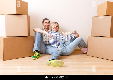 Foto der jungen Paare sitzen auf dem Boden der Kartons Stockfoto