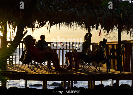 Die Menschen genießen den Sonnenuntergang von einem Bungalow am Strand, schwarze Korallen Insel Pohnpei, Föderierte Staaten von Mikronesien Stockfoto