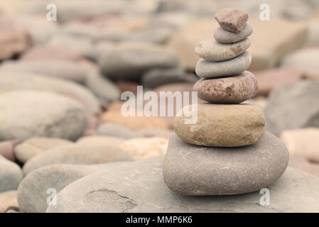 Haufen von Steinen auf einem Kiesstrand in warmes Abendlicht. Ruhige friedliche zen Konzept Stockfoto