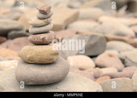 Haufen von Steinen auf einem Kiesstrand in warmes Abendlicht. Ruhige friedliche zen Konzept Stockfoto