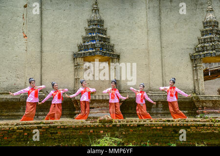 Kanchanaburi, Thailand - 24. Juli 2016: Schöne Mädchen im Teenageralter mit Mon tradition Kleider tanzen Touristen in der Nähe der verfallenen Buddhistischen Kirche in zu zeigen Stockfoto