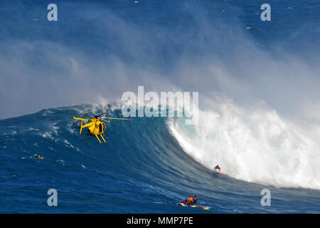 Support Team und dem Häcksler zu beobachten, eine riesige Welle bricht während der 2015 Peahi Herausforderung Big Wave Surfen Meisterschaft in Kiefer, Maui, Hawaii, USA Stockfoto