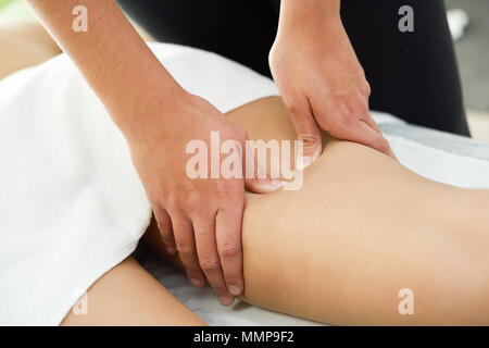 Medizinische Massage am Bein in einer Physiotherapie. Weiblichen Physiotherapeuten ihre Patienten untersuchen. Stockfoto