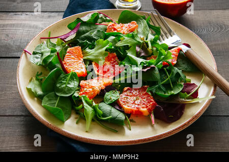 Frischer Salat Mix mit blutorangen auf einer hölzernen Hintergrund. Ansicht von oben. Gesunde Ernährung Konzept. Stockfoto