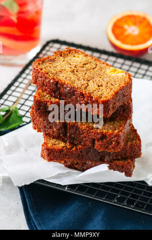 Scheiben von Blut orange vegetarische Pound Cake auf einem Rack. Weißer Stein Hintergrund. Stockfoto