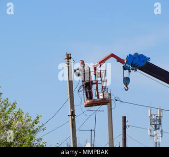 Slavjansk-auf-Kuban, Russland - 24 April, 2018: Elektriker die Stromversorgung reparieren. Arbeitnehmer sind Schlosser Elektriker. Stockfoto