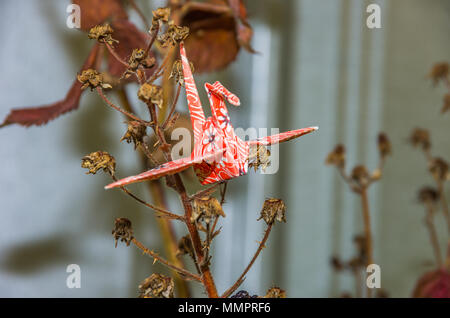 Origami Papier Kran aus original japanischen Origami Papier in einem natürlichen Garten Umgebung eingerichtet. Stockfoto