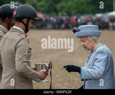 Queen Elizabeth II enthält die Preise für die Show Jumping team von Bahrain nach dem Land Rover Services Team Springen bei Tag vier der Royal Windsor Horse Show im Schloss Windsor, Berkshire. Stockfoto