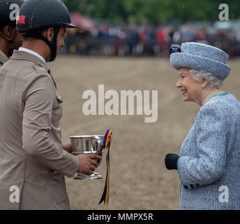 Queen Elizabeth II enthält die Preise für die Show Jumping team von Bahrain nach dem Land Rover Services Team Springen bei Tag vier der Royal Windsor Horse Show im Schloss Windsor, Berkshire. Stockfoto