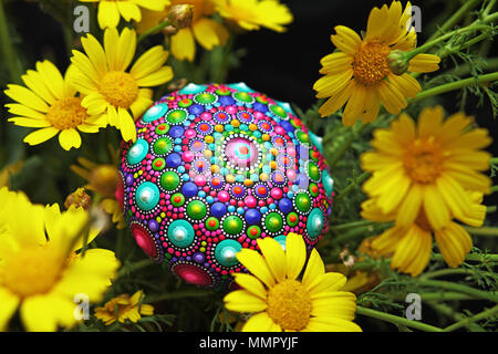 Wunderschöne handbemalte Mandala Stein mit gelben Blumen Stockfoto