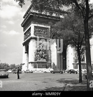 In den 1950er Jahren fahren Kraftfahrzeuge um das ikonische Triumphbogen-Denkmal in Paris, Frankreich, das sich am Place de l'Etoile und an der Avenue des Champ Elysees befindet und gebaut wurde, um den französischen Kommandanten, Napoleons militärische Siege zu feiern. Stockfoto