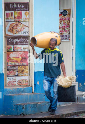 Trinidad, Kuba, Nov 26, 2017 - Man geht die Straße runter, seine Trommel auf seine Schulter und Hut in der Hand Stockfoto