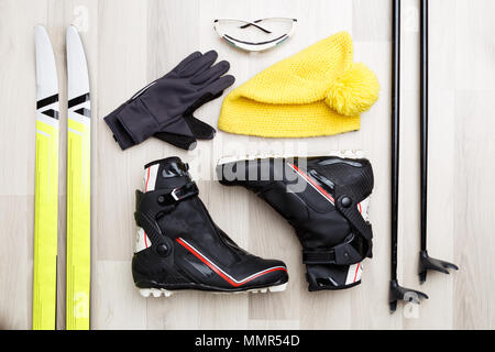 Bild von Skifahrer Zubehör auf Holz- Hintergrund. Skier, Stöcke, Schuhe, Mütze. Stockfoto