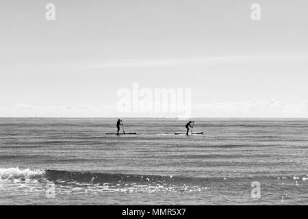 Paddle Boarding Silhouetten in einer ruhigen Mittelmeer, ein schwarz-weiß Foto mit Freiraum für Text Stockfoto
