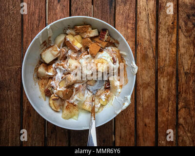 Schüssel mit Joghurt, cinnemon, Birne, Haferflocken und Löffel Stockfoto