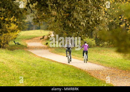 Zwei Radfahrer auf Herbst weg. Nicht identifizierte Personen mit dem Rücken zum Betrachter Stockfoto