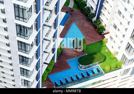 Details moderner Gebäude Außen-Terrasse in Hochhaus mit Swimmingpool, Lounge Zone, grünen Bäumen. Alles, was Sie für einen komfortablen Aufenthalt, ideal Stockfoto