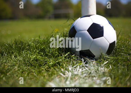 Ein schwarzes und weißes Leder Fußball in der Nähe der Post und weiße Linie Stockfoto