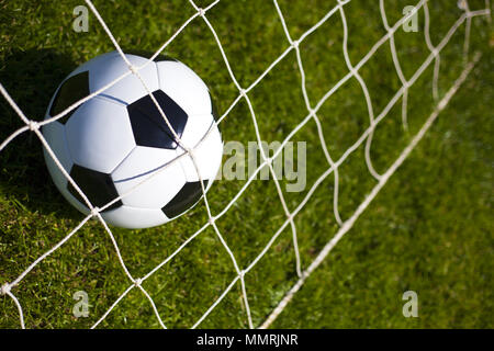 Einen schwarz-weißen Fußball hinter einem Net Stockfoto