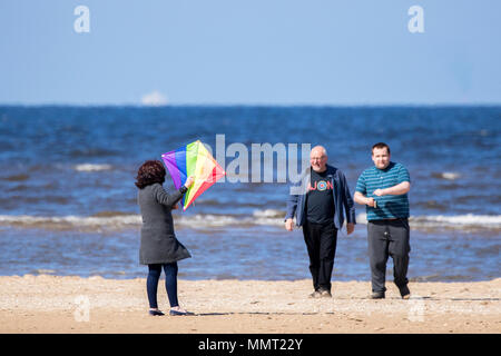 Southport, Merseyside. 13. Mai 2018. UK Wetter. Eine Frau hat viel Spaß gemacht, die versuchen, ihre Drachen am goldenen Sandstrand von Southport Strand in Merseyside zu fangen. Credit: cernan Elias/Alamy leben Nachrichten Stockfoto