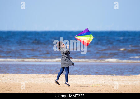 Southport, Merseyside. 13. Mai 2018. UK Wetter. Eine Frau hat viel Spaß gemacht, die versuchen, ihre Drachen am goldenen Sandstrand von Southport Strand in Merseyside zu fangen. Credit: cernan Elias/Alamy leben Nachrichten Stockfoto