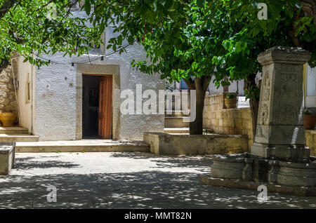 Chersonissos, Kreta/Griechenland. Die "Heilig-Kreuz-Kapelle" in Archanes Village. Stein Brunnen im Innenhof Stockfoto