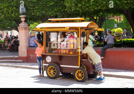 Einen Snack essen stehen im Jardin Principal in San Miguel de Allende Stockfoto