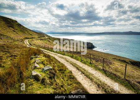 Eine ländliche, unbefestigte Straße, die sich bis zu den Bergen Urris in Donegal Irland geht. Es liegt in unmittelbarer Nähe des Meeres. Stockfoto