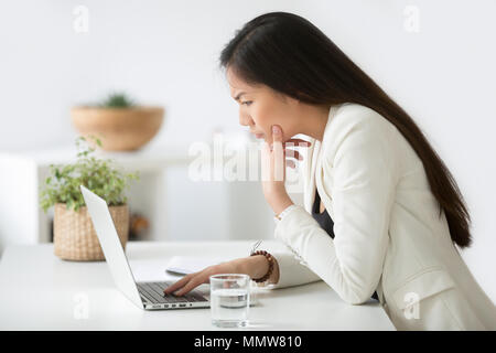 Verwirrt asiatische Frau denken schwer am Laptop scr suchen Verwirrt Stockfoto