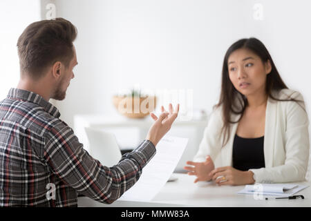 Asiatische und kaukasischen Partner Verhandlungen über contr uneinig Stockfoto