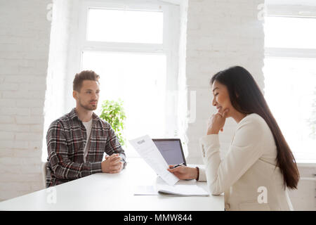 Lächelnd hr Lesen wieder auf Job- Interview mit schweren candidat Stockfoto