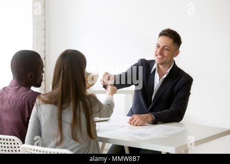 Happy interracial Paare erhalten Schlüssel zum neuen Haus von Realtor Stockfoto