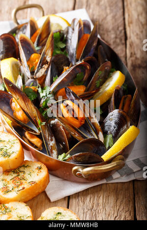 Miesmuscheln in Wein mit Petersilie und Zitrone. Fisch und Meeresfrüchte. Muscheln in die Tanks. Leckerer Snack für Feinschmecker. Vertikale, rustikalen Stil Stockfoto