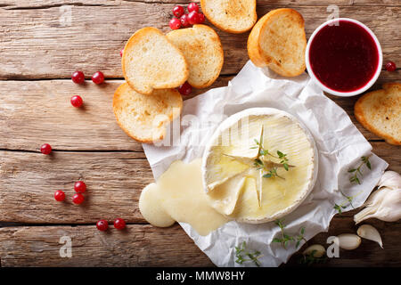 Geschmolzene würzige Camembert mit Knoblauch, Thymian und Olivenöl close-up auf den Tisch. Horizontal oben Ansicht von oben Stockfoto