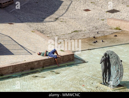 Bologna, Italien - 15 April 2018:. Ein unbekannter Mann entspannt unter der Sonne in der modernen Stadt Platz. Am Nachmittag in der Innenstadt entspannen Stockfoto