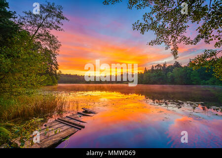 Helle Sonnenaufgang an einem See. Stockfoto