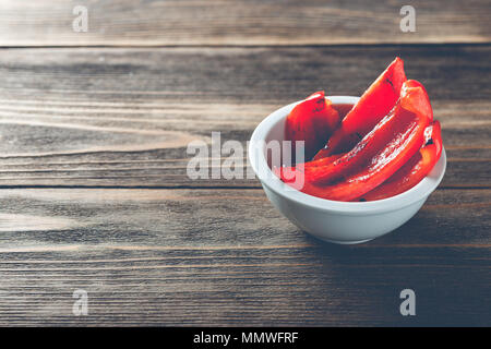 Red gegrillte Paprika in Weiß Schüssel auf Holz- Hintergrund, kopieren Platz für Text Stockfoto