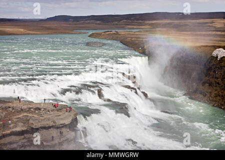 Der obere Teil des riesigen Wasserfall Gullfoss in Island mit sehr kleinen aussehende Touristen. Stockfoto