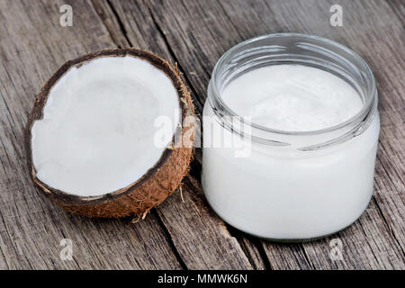 Kokosöl in Glaswaren auf hölzernen Tisch Stockfoto