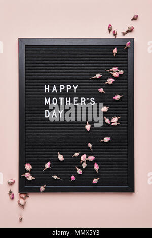 Schwarz mit weißem Kunststoff letterboard Briefe mit Zitat Happy Mother's Day, mit getrockneten Blumen auf rosa Hintergrund eingerichtet. Stockfoto