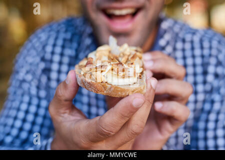 Lächelnd Mann über zu essen ein leckeres Sandwich konfrontiert Stockfoto