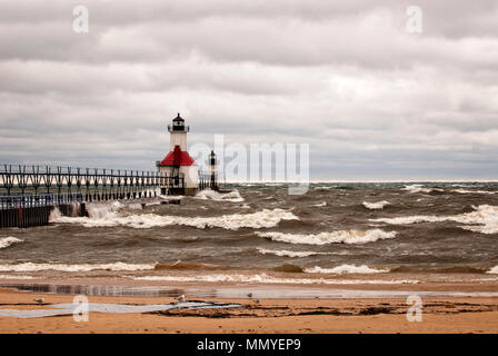 Einen kleinen Leuchtturm auf einem Pier in St. Joeseph Michigan während stromy Wetter mit Wellen, die in die Pier. Stockfoto