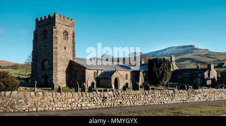 Schnee bedeckt Pen-y-Ghent hinter St. Oswalds Kirche in Horton-in-Ribblesdale, England. Stockfoto