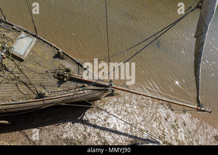 Eine alte hölzerne traditionell Segeln yacht oder Boot verlassen oder Schiffbruch againsta vergessen eine Wand in einem Hafen auf der Isle of Wight günstig gebaut. Stockfoto