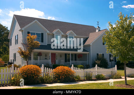 Schöne alle Holz neues Zuhause mit traditionellen amerikanischen Landhausstil Architektur. Große Veranda mit Schaukelstühlen und eine Hollywoodschaukel. Stockfoto