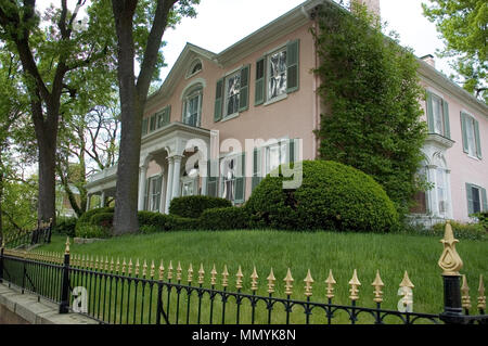 Interessante Farbe von Rosa zu diesem Haus. Schönen schmiedeeisernen Zaun details Sie zum Haupteingang mit Spalten führen. Stockfoto