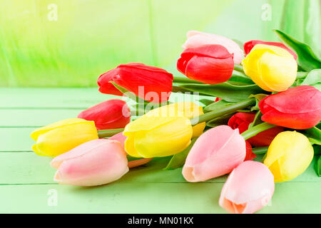 Blick von oben auf die schöne Frühling bunte Tulpen Bouquet und Geschenk mit Schleife auf alten hölzernen Hintergrund Stockfoto